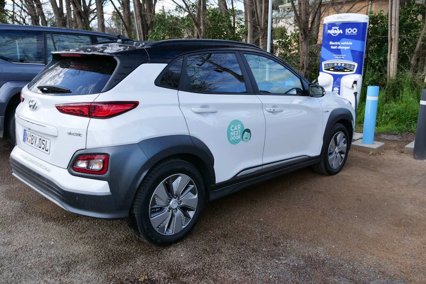 electric car next to charging bowser