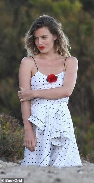 With a shock of red lipstick to match a decorative flower, the 29-year-old oozed glamour in the Californian sun