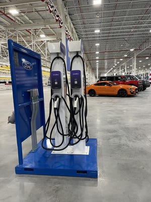 An electric vehicle charging station and Ford vehicles are displayed inside the automaker's Rouge Electric Vehicle Center for President Joe Biden's visit Tuesday, May 18, 2021.