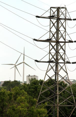 The Narragansett Bay Commission's wind turbines at Fields Point, with transmission lines in the foreground.