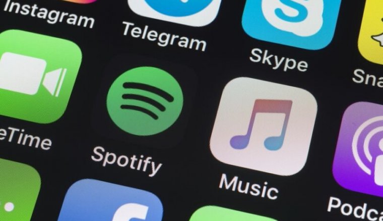 App icons for Spotify, Apple Music, and other apps on an iPhone screen.