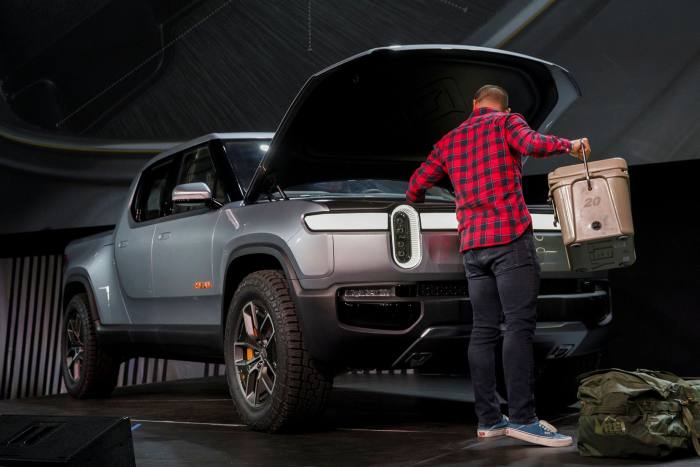 An employee uses the front trunk of a Rivian Automotive R1T electric pick-up truck