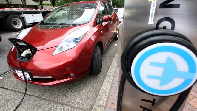 A Nissan Leaf charges at an electric vehicle charging station.