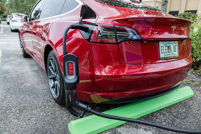 Using a Tesla charging adapter, a Tesla sedan gets a charge at the new EVolution charging station at Midtown in Palm Beach Gardens, Friday, October 2, 2020. There are four Level 3 (fast) charging stations, and two Level 2 (slower charging) stations at the site. Florida Power & Light is commemorating National Drive Electric Week with the debut of a new electric vehicle universal fast-charging station at Mainstream in Midtown in Palm Beach Gardens. Customers will be charged about 30 cents per kilowatt hour to charge their electric vehicles. [JOSEPH FORZANO/palmbeachpost.com]