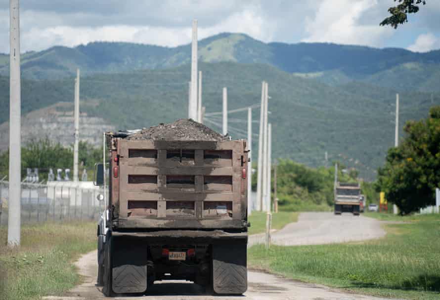 Dump trucks leave the AES coal-burning power plant, known as La Carbonera by locals, in Guayama.